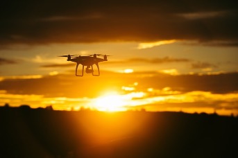 Silhouet van een drone tegen een zonsondergang